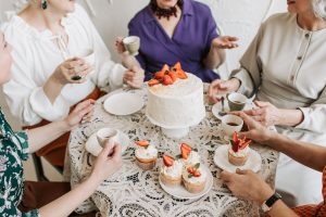 Gruppo di donne intorno a un tavolo a bere caffè.